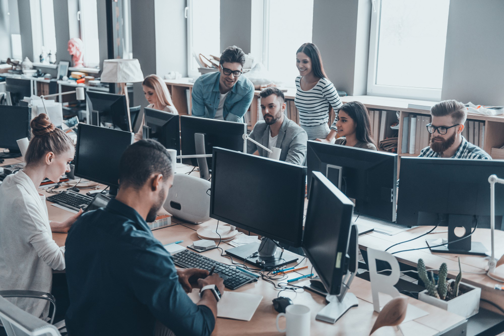 Company employees in the office with lots of computers to represent SharePoint Online development